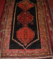 Lot 692 - A Persian woollen rug, having a poled field...