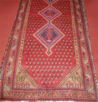 Lot 693 - A Persian woollen rug, having a red ground...