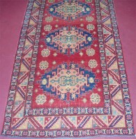 Lot 701 - A Persian woollen Kazak rug, having a triple...