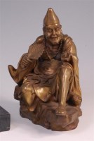 Lot 40 - An Oriental gilt bronze seated figure, holding...