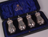 Lot 468 - A cased set of four Edwardian silver peppers,...