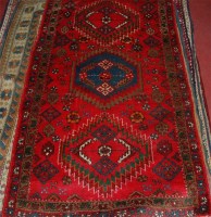 Lot 809 - A Kurdish woollen red ground rug, decorated...