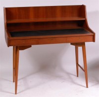 Lot 372 - A 1960s teak writing desk, having black rexine...