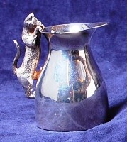 Lot 181 - A modern silver novelty cream jug, the handle...