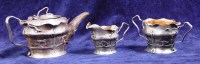 Lot 233 - An Arts & Crafts silver three piece teaset, of...