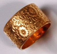 Lot 666 - A 22ct gold wedding band, with leaf and flower...