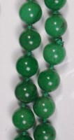 Lot 675 - A spinach jade beaded necklace, each bead...