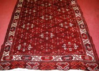 Lot 513 - A Persian woollen red ground Bokhara rug, the...