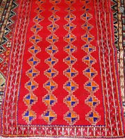 Lot 493 - A Persian woollen red ground rug, decorated...