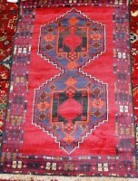 Lot 494 - A small Persian woollen rug, the red ground...