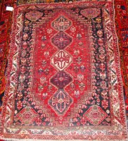 Lot 496 - A Persian woollen Shiraz rug, the red ground...