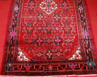 Lot 515 - A Persian woollen red ground rug, the field...