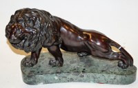 Lot 51 - A bronze figure of a lion in stalking pose on...