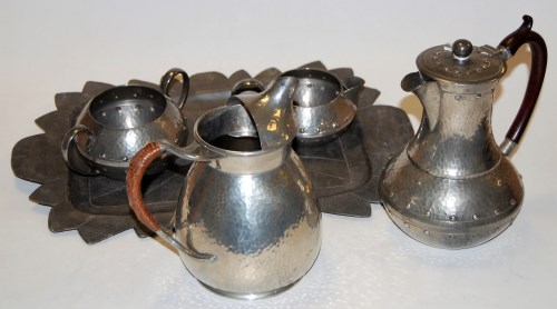 Lot 56 - An Arts & Crafts spot hammered pewter three...