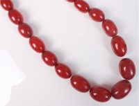 Lot 403 - A faux 'cherry amber' bead necklace, 82cm long