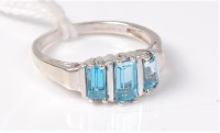 Lot 435 - A 9ct white gold three stone topaz ring, the...