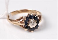 Lot 446 - A 9ct sapphire and diamond cluster ring, the...