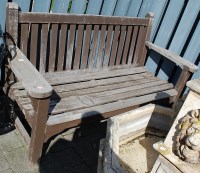 Lot 1173 - A stained and slatted teak three-seater garden...