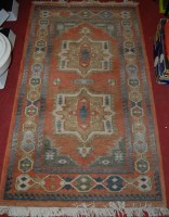 Lot 1189 - A small Persian woollen rug having a geometric...