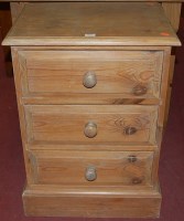 Lot 1447 - A modern pine three drawer bedside chest,...