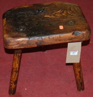 Lot 1487 - A rustic elm three legged milking stool