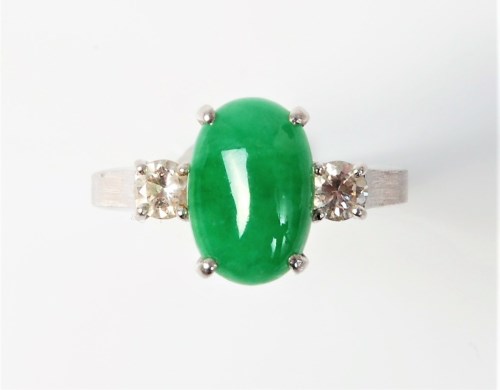 Lot 2538 - A jade and diamond ring, the oval jade...