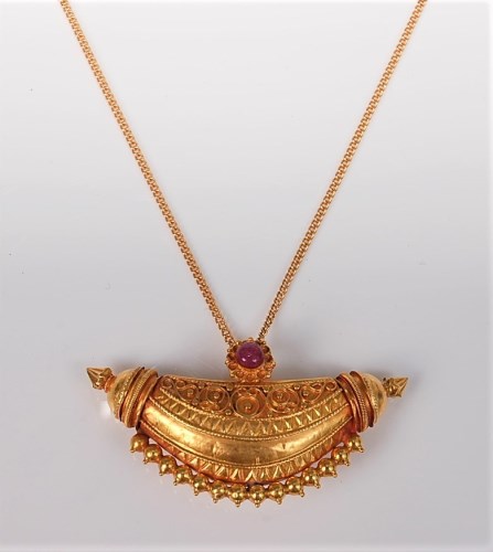 Lot 2562 - A ruby and yellow precious metal pendant, the...