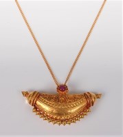 Lot 2562 - A ruby and yellow precious metal pendant, the...