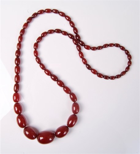 Lot 2600 - A faux 'cherry amber' necklace, the oval...