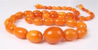 Lot 2602 - An amber bead necklace, the oval graduated...