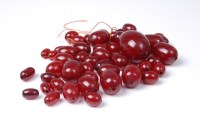 Lot 2641 - A faux 'cherry amber' bead necklace, the...
