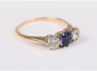 Lot 2718 - A three stone sapphire and diamond ring, the...