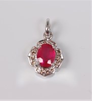 Lot 2726 - A treated ruby and diamond pendant, the oval...