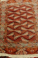 Lot 2460 - A Persian woollen Yomut rug, the rust coloured...