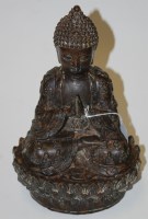 Lot 116 - A bronzed figure of a Buddha in typical seated...