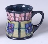 Lot 67 - A Moorcroft pottery mug in the Violet pattern,...
