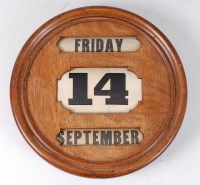 Lot 475 - An Art Deco oak wall mounted date calendar, of...