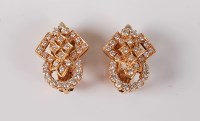 Lot 1142 - A pair of diamond earclips, the stylised...