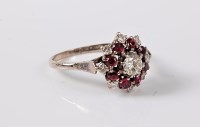Lot 1171 - A ruby and diamond cluster ring, the central...