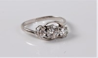 Lot 1197 - A three stone diamond crossover ring, the...