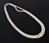 Lot 1204 - A two strand pearl necklace, the graduated...