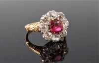 Lot 1212 - A ruby and diamond ring, the central round...
