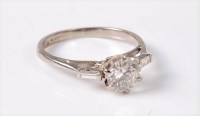 Lot 1223 - A diamond ring, the central round brilliant...