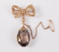 Lot 2512 - A smokey quartz pendant/brooch, the oval...
