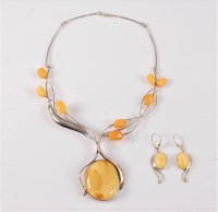 Lot 2521 - An amber necklace and earrings, the large...