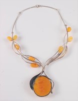 Lot 2521 - An amber necklace and earrings, the large...