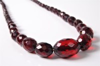 Lot 2523 - A faux 'cherry amber' bead necklace, the...