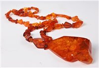 Lot 2526 - An amber necklace and two amber simulant...