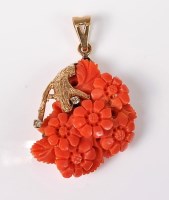 Lot 2527 - A carved coral and diamond pendant, the floral...