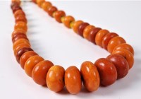 Lot 2530 - An amber and paste bead necklace, the slightly...